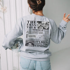 a woman wearing a gray sweatshirt and jeans