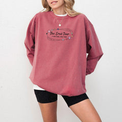 a woman wearing a pink sweatshirt and black shorts