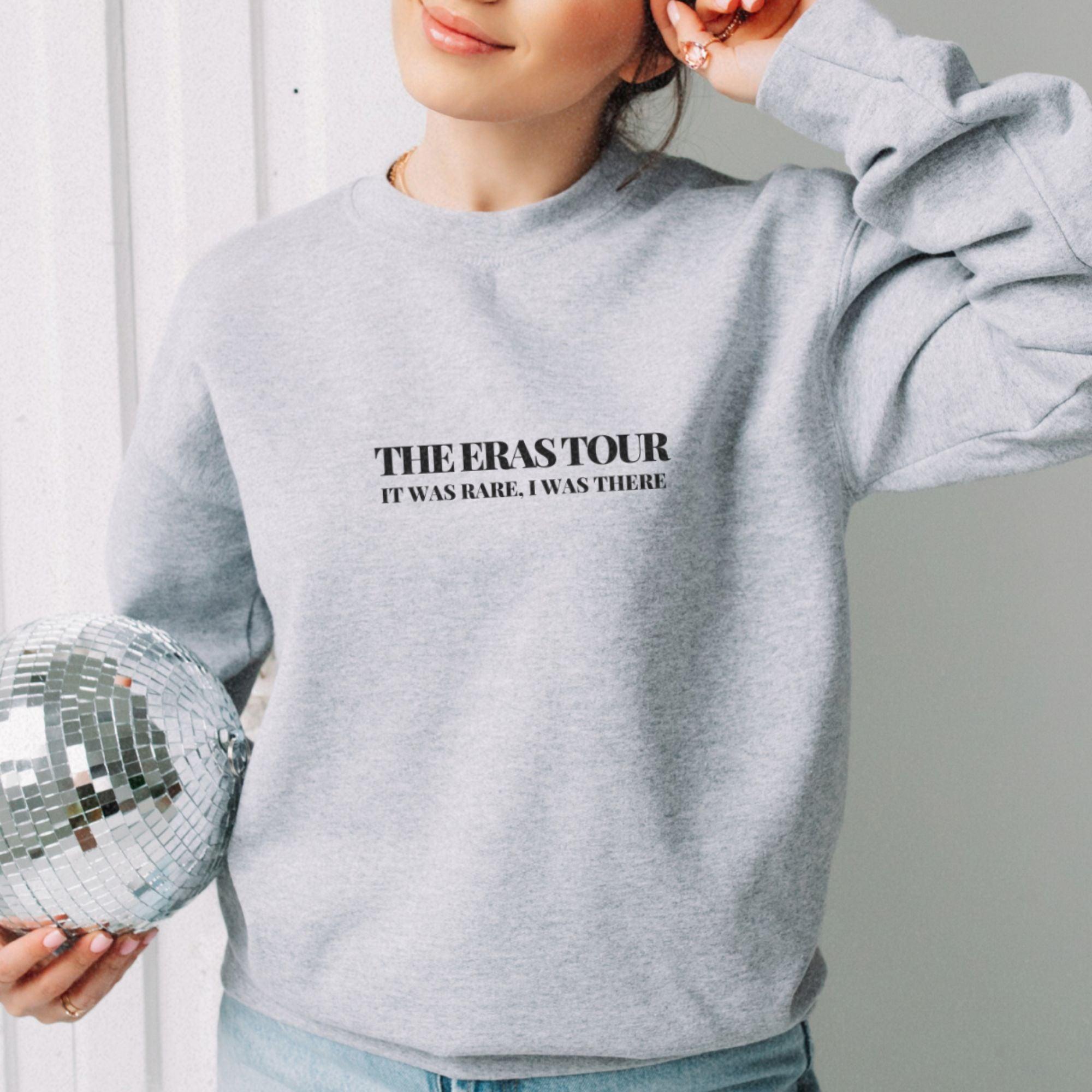 a woman holding a disco ball and wearing a sweatshirt