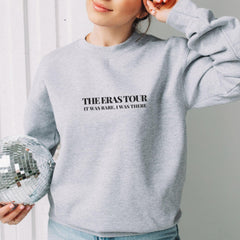 a woman holding a disco ball and wearing a sweatshirt