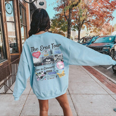 a woman in a blue sweatshirt is walking down the sidewalk