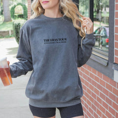 a woman is holding a drink and wearing a hat