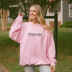 a woman wearing a pink sweatshirt and jeans