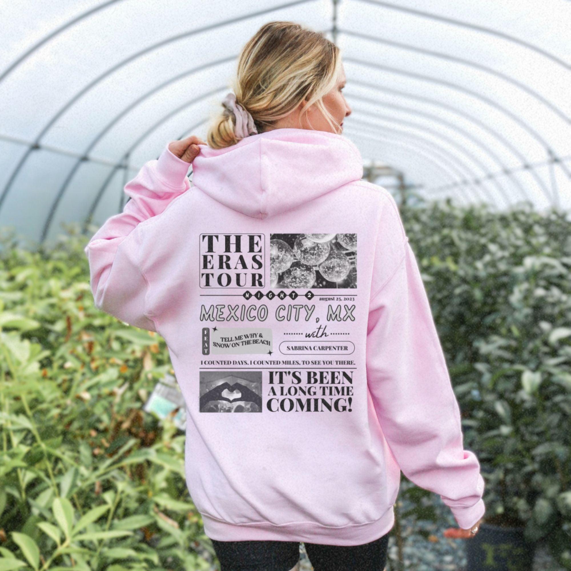 a woman wearing a pink hoodie in a greenhouse