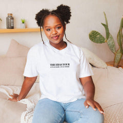 a woman sitting on a bed wearing a white shirt