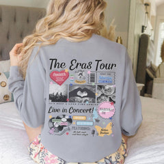 a woman sitting on top of a bed wearing a gray shirt