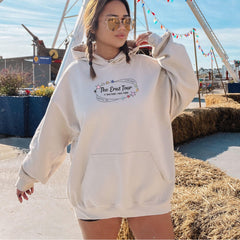 a woman in a white hoodie is standing in front of a ferris wheel