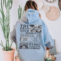 a woman in a blue hoodie is standing next to a cactus