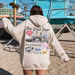 a woman in a white hoodie is walking on the beach