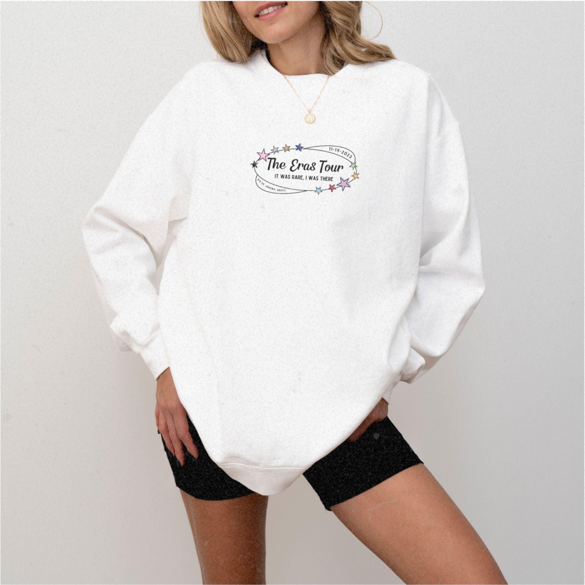 a woman wearing a white sweatshirt and black shorts
