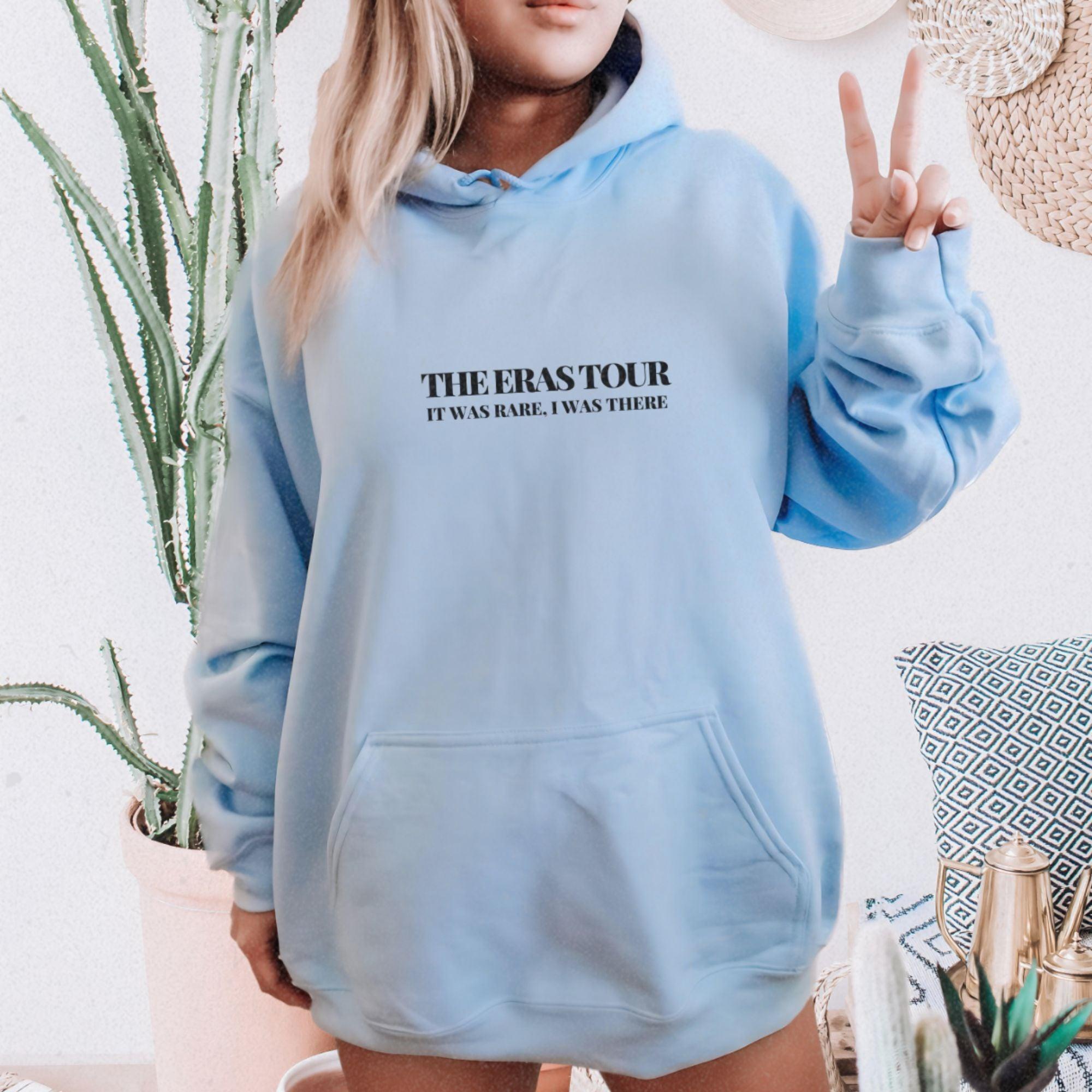a woman in a blue hoodie holding up a peace sign