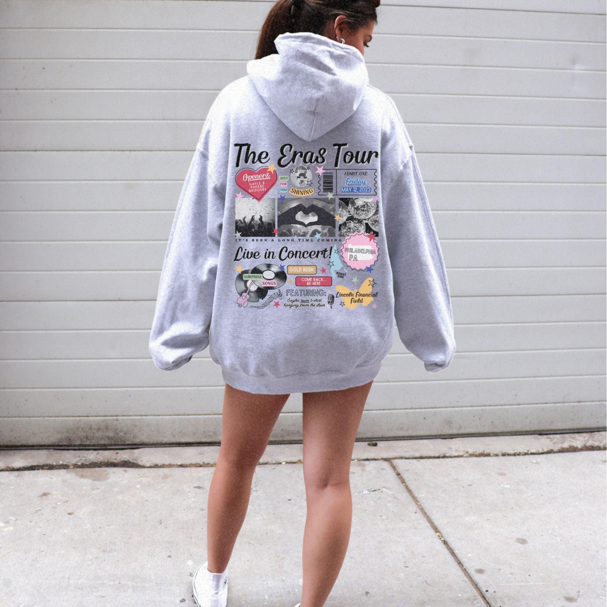 a woman in a gray hoodie is walking down the street