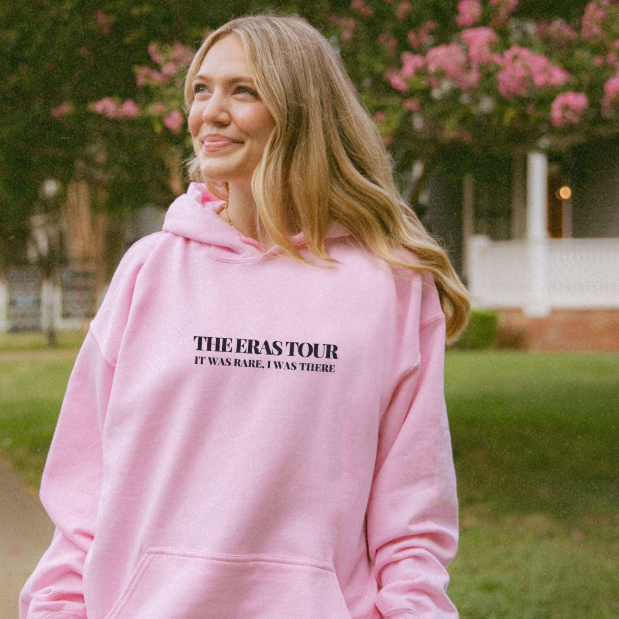 a woman in a pink hoodie is smiling