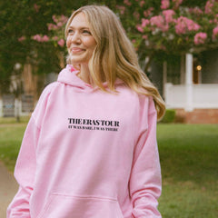 a woman in a pink hoodie is smiling
