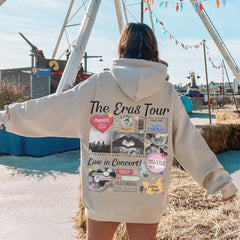a woman in a white hoodie standing in front of a ferris wheel