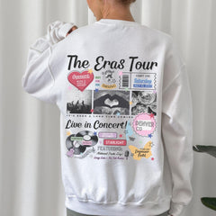 a woman wearing a white sweatshirt with the words the eras tour printed on it