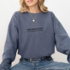 a woman sitting on a chair wearing a sweatshirt