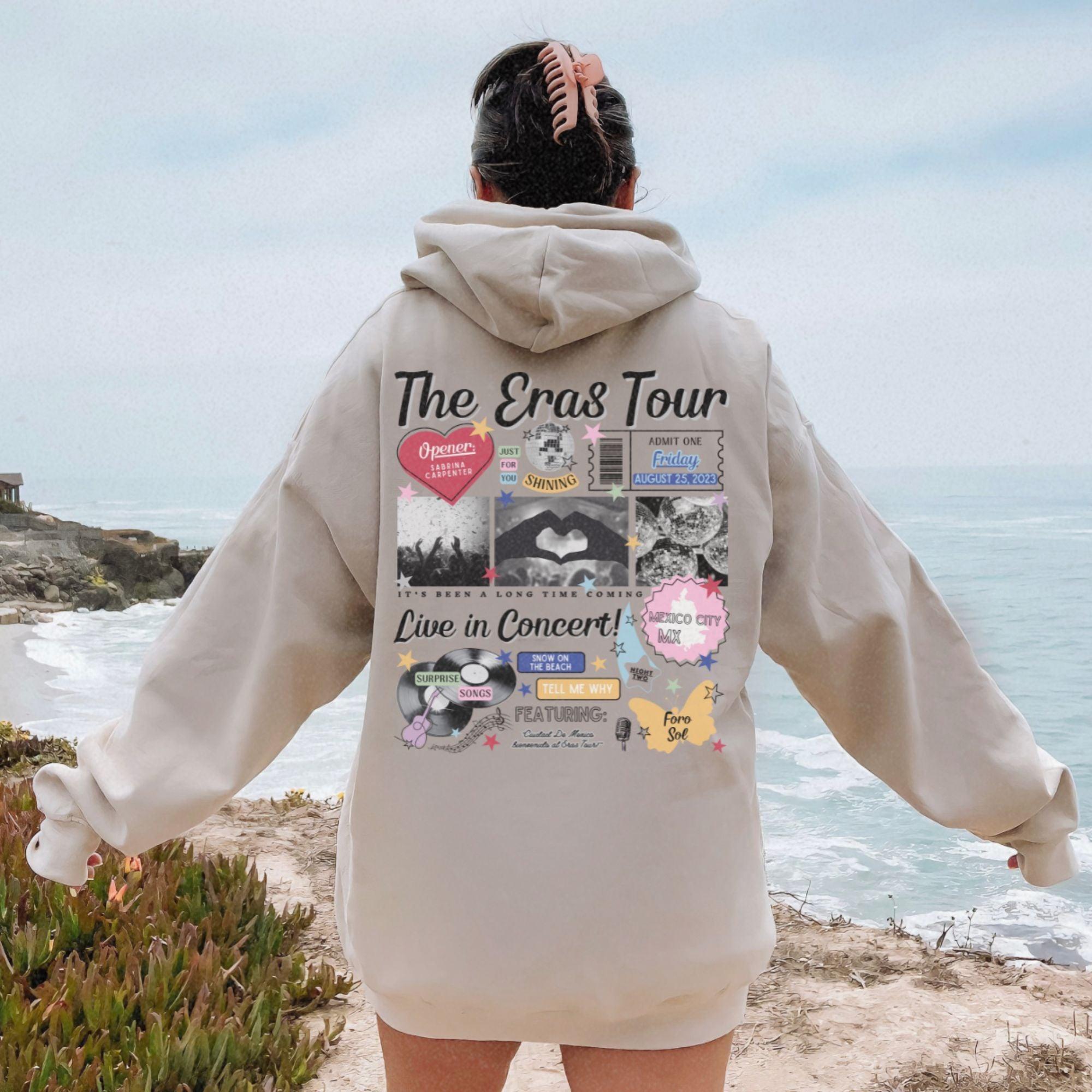 a person standing on a beach with a hoodie on