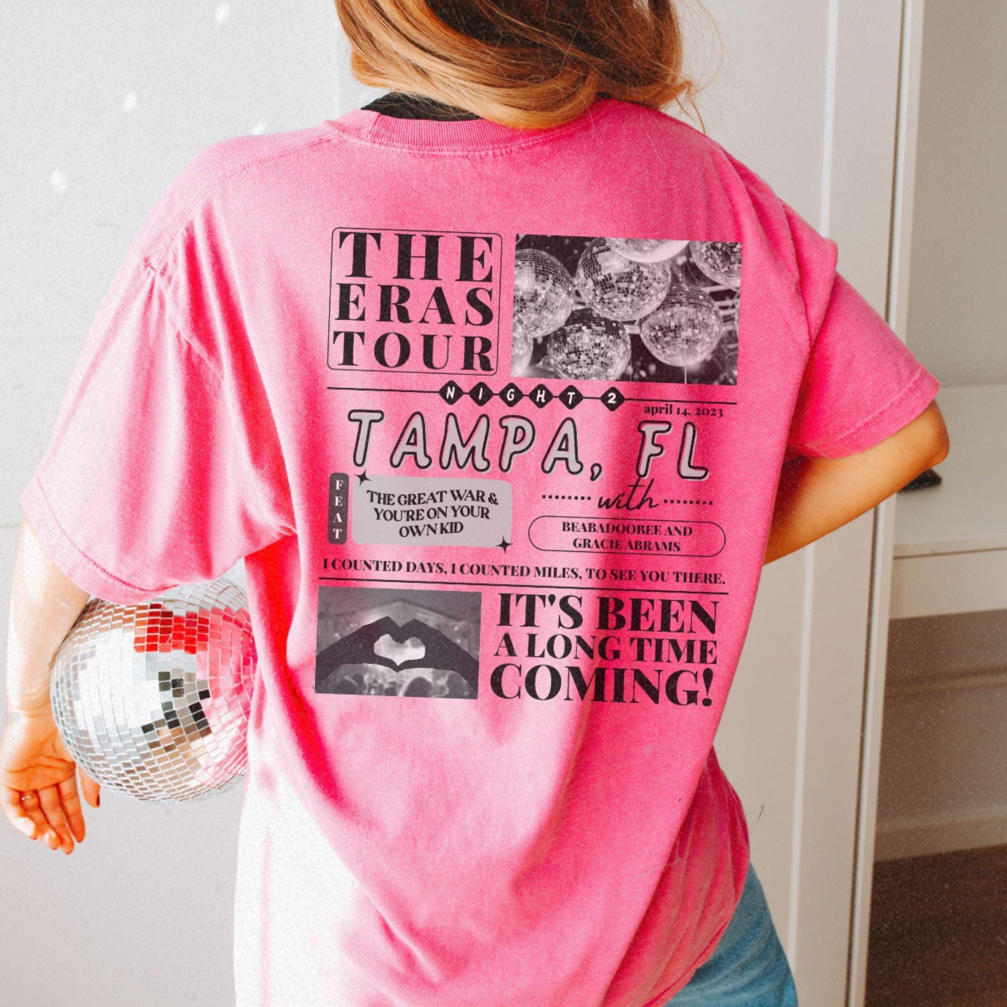 a woman in a pink shirt holding a disco ball