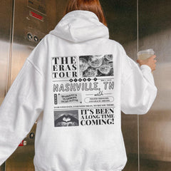 a woman in a white hoodie holding a cup of coffee