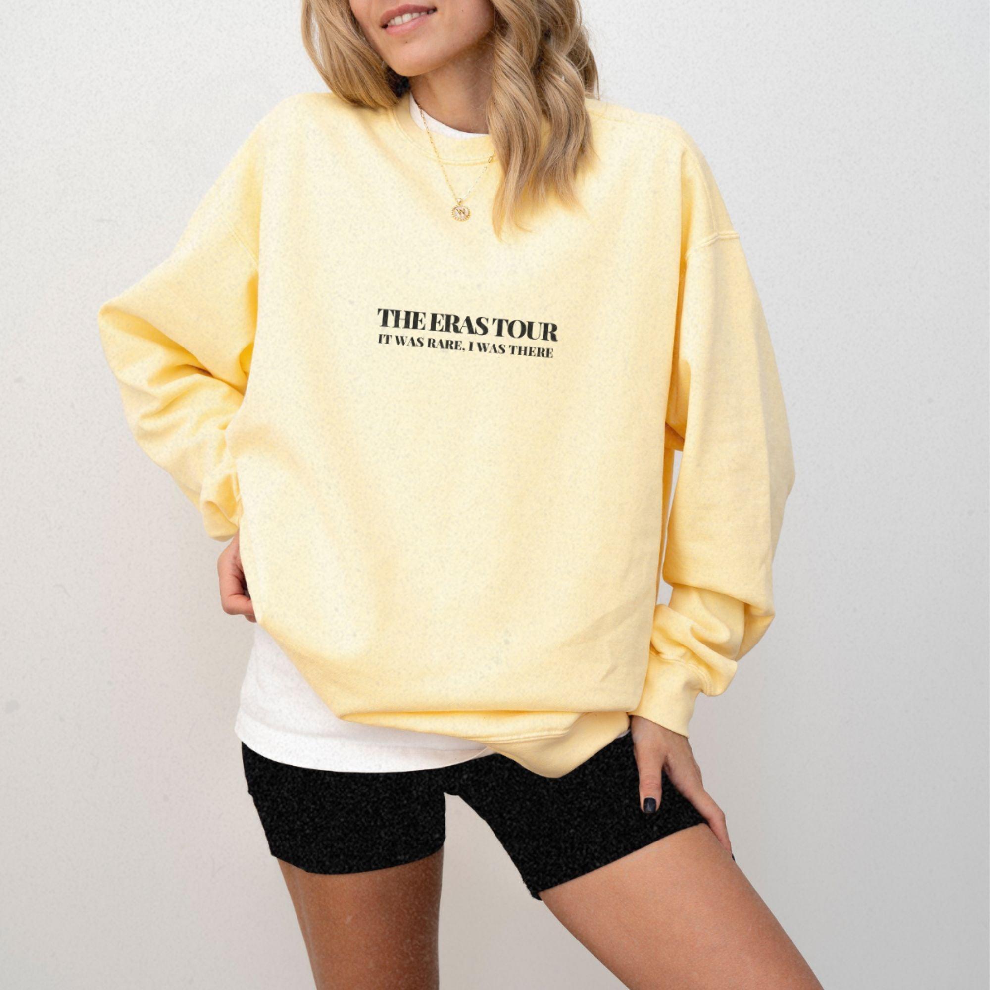 a woman wearing a yellow sweatshirt and black shorts