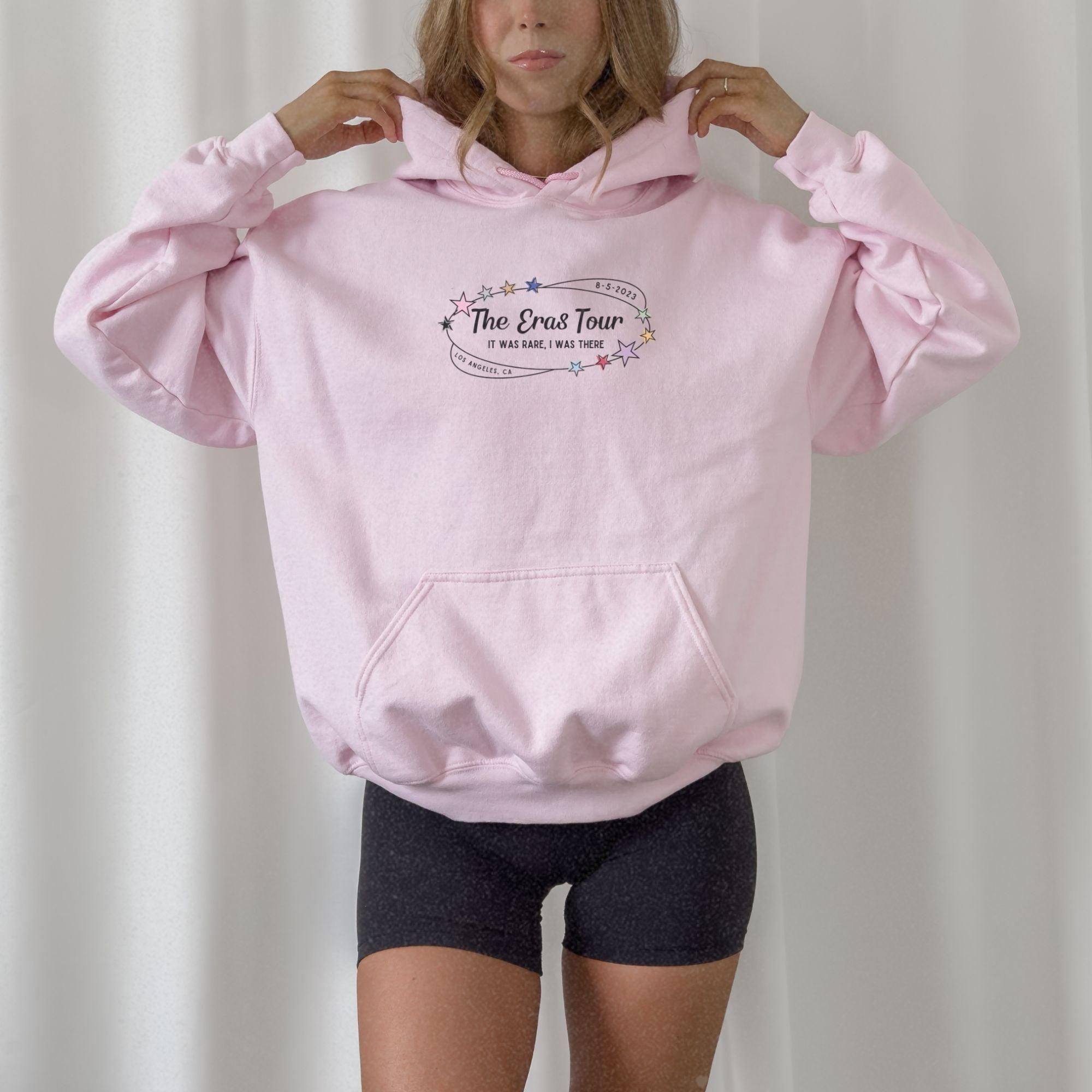 a woman wearing a pink hoodie and black shorts