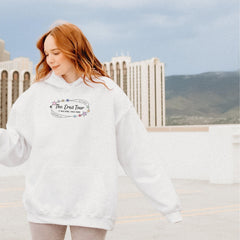a woman with red hair wearing a white hoodie