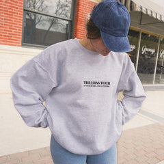 a woman standing on a sidewalk with a skateboard