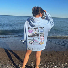 a woman standing on a beach with a towel over her head