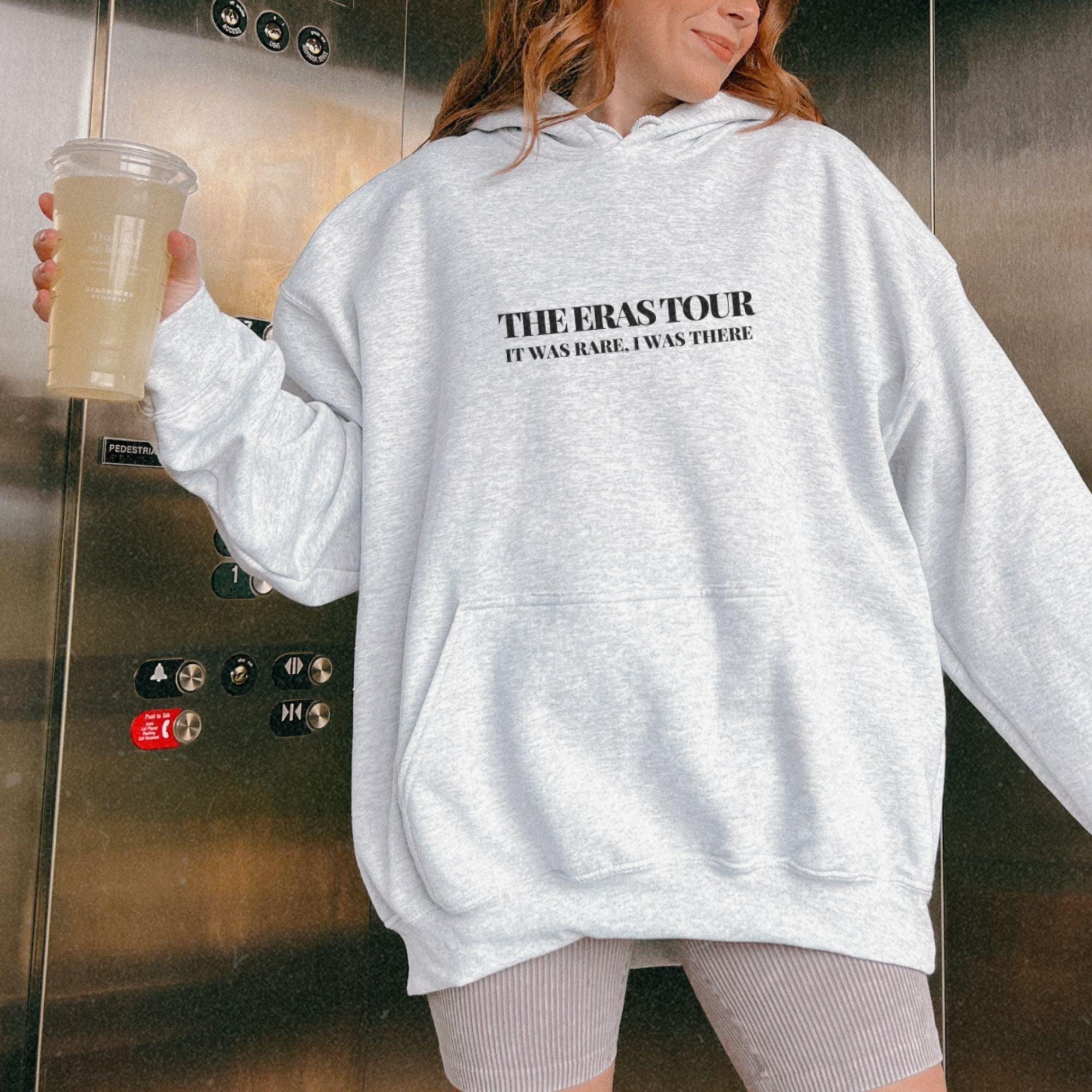 a woman standing in front of a refrigerator holding a drink