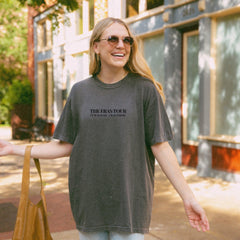 a woman walking down a street holding a brown bag