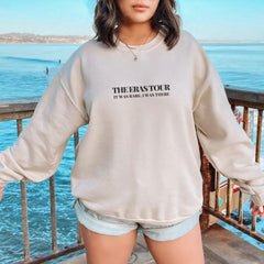 a woman wearing a sweatshirt and shorts standing on a pier