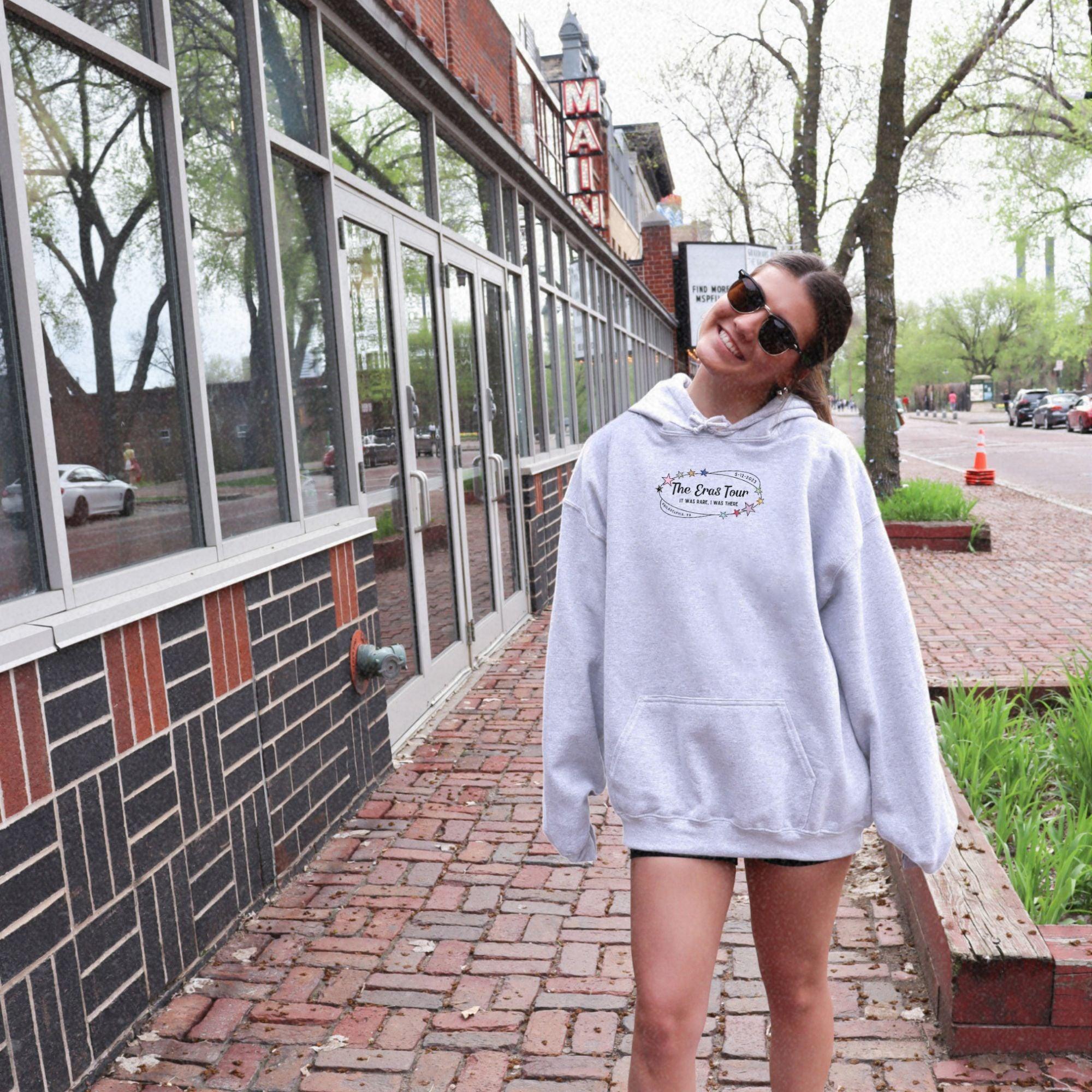 a woman in a white hoodie is walking down the street