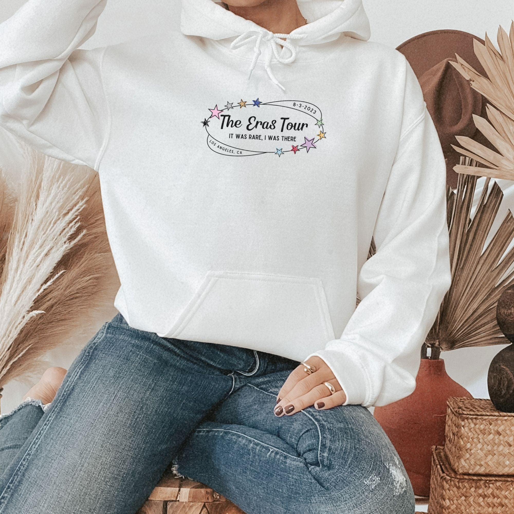 a woman sitting on a chair wearing a white hoodie